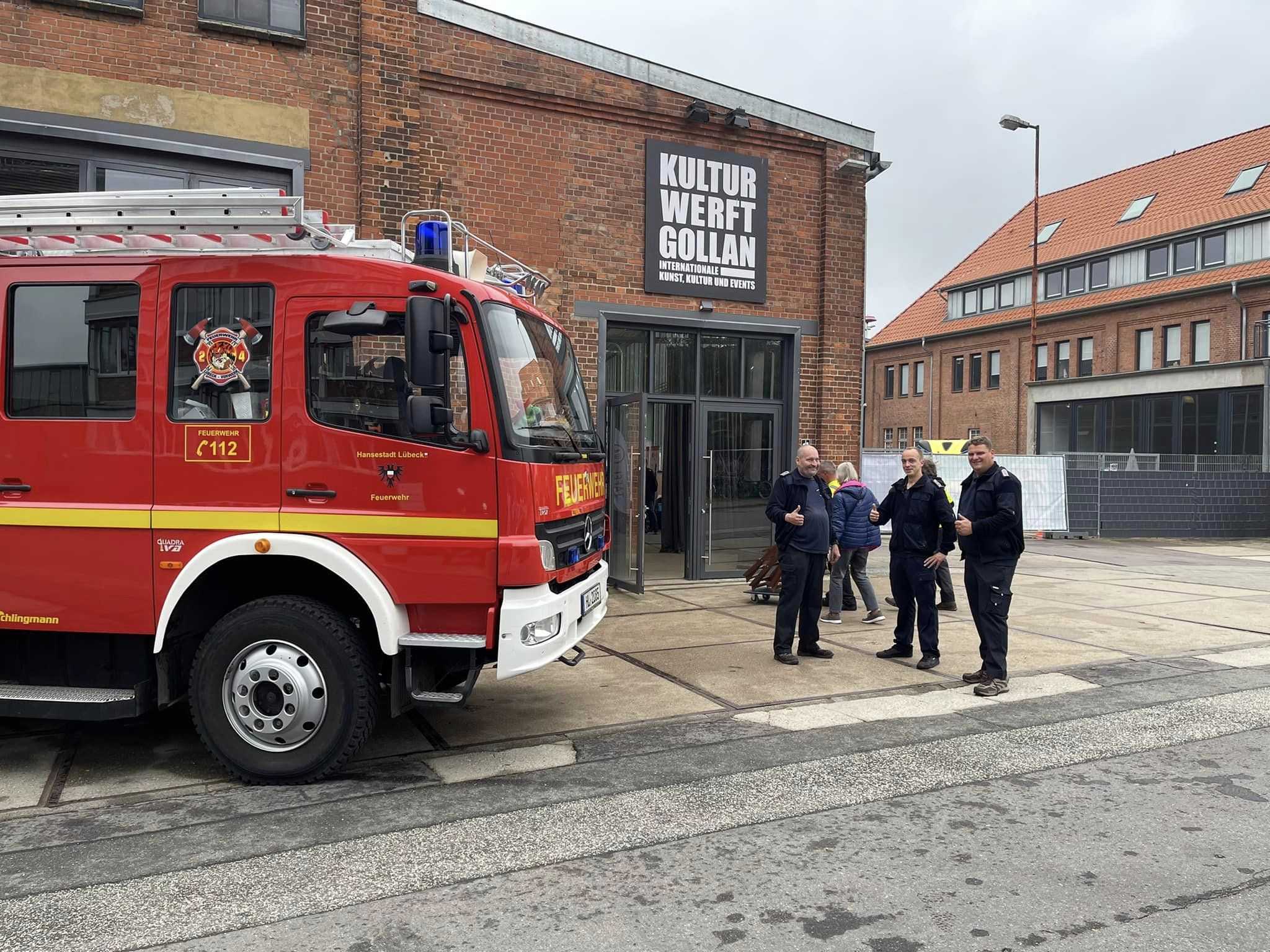 Ein Feuerwehrfahrzeug steht vor einer alten Fabrikhalle.